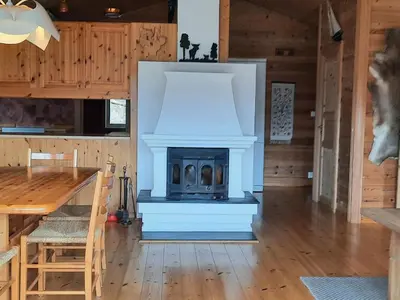 a living room with a fireplace and a table at Holiday Home Häuschen mit Blick auf das Wasser by Interhome in Ropeid