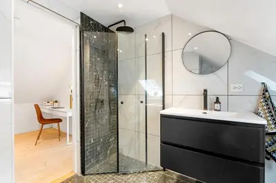 a bathroom with a shower and a sink and a mirror at Modern 3-bedroom apartment with a view in Trondheim