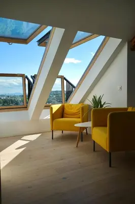 a living room with two yellow chairs and windows at Modern 3-bedroom apartment with a view in Trondheim