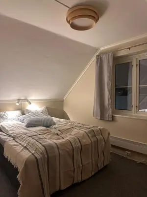 a bedroom with a bed with a lamp and a window at Great house Hamar, stay close to Mjøsa at Domkirkeodden in Hamar