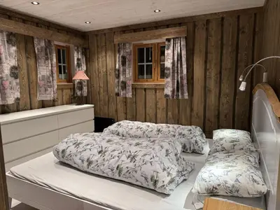 two beds in a bedroom with wooden walls at Large cottage with beautiful view in Trysil in Trysil
