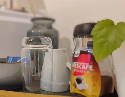 a table with a bottle of milk and a glass container at Women Only - Guestroom in centre of Førde town in Førde
