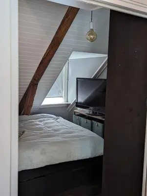 a bedroom with a bed and a flat screen tv at Apartment centrally located in Trondheim in Trondheim