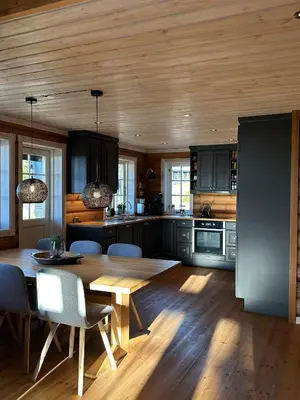 a kitchen with a wooden ceiling and a wooden table at Exclusive family cabin in Hafjell ski-in-ski-out in Hafjell