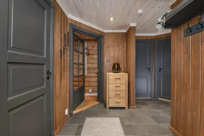 a hallway with wood paneled walls and a door at Exclusive family cabin in Hafjell ski-in-ski-out in Hafjell