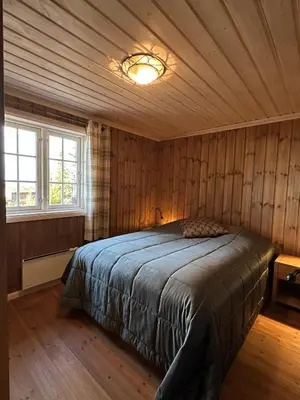 a bedroom with a bed in a room with wooden walls at Exclusive family cabin in Hafjell ski-in-ski-out in Hafjell