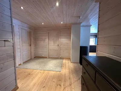 a large room with wooden walls and wooden flooring at Botn Fjellstue in Botn
