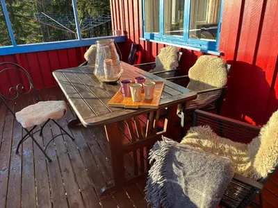 a wooden table and chairs on a deck at Magic Cabin by Lake & Forest , Peace, Views & Outdoor Fun, in Opphus