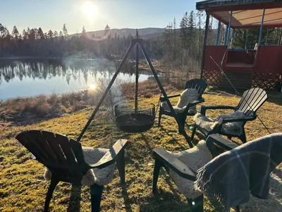 a group of adirondack chairs and a fire swing at Magic Cabin by Lake & Forest , Peace, Views & Outdoor Fun, in Opphus