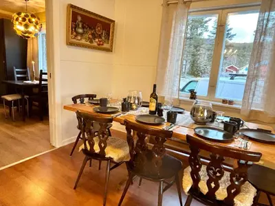 a dining room table with chairs and a bottle of wine at Magic Cabin by Lake & Forest , Peace, Views & Outdoor Fun, in Opphus