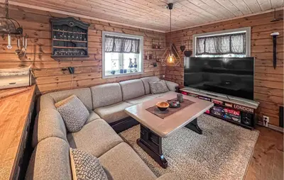 a living room with a couch and a large television at Awesome Home In Gålå With Sauna in Gålå