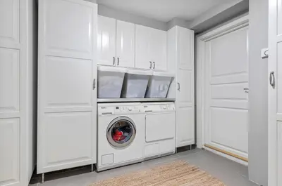 a white laundry room with a washer and dryer at Spacious 3 Bedroom Basement Apartment with Parking, Close to Trondheim City Center in Trondheim