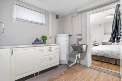 a kitchen with a sink and a bed in a room at Spacious 3 Bedroom Basement Apartment with Parking, Close to Trondheim City Center in Trondheim