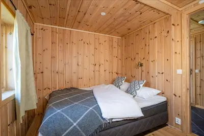 a bedroom with a bed in a wooden room at Rundetjødn 20 in Hol