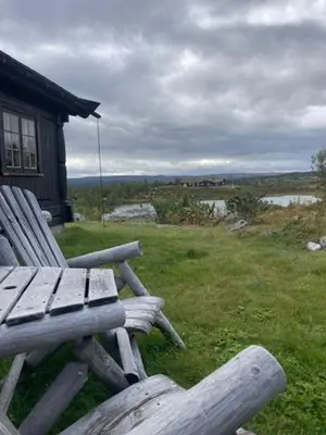 a wooden bench sitting on top of a field at Rundetjødn 20 in Hol
