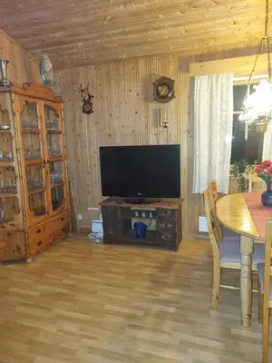 a living room with a flat screen tv and a table at Idyllic house on a farm in Steinkjer