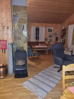 a living room with a fireplace and a stone wall at Idyllic house on a farm in Steinkjer