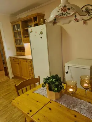 a kitchen with a table and a white refrigerator at Idyllic house on a farm in Steinkjer