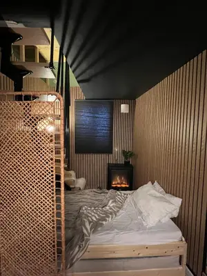 a bedroom with a bed and a fireplace at Central Bergen Stay for Families & Groups-6 Guests in Bergen