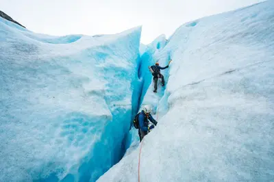 two people are climbing on a snow covered glacier at Central Stay Odda in Odda