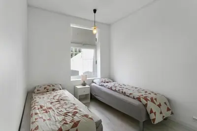 a bedroom with two beds and a window at Centrum apartment 2 in Ålesund