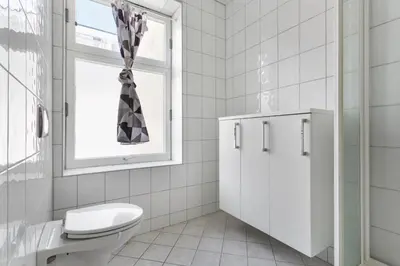 a bathroom with a toilet and a window at Centrum apartment 2 in Ålesund