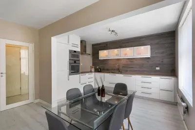 a kitchen with a glass table and some chairs at Centrum apartment 2 in Ålesund