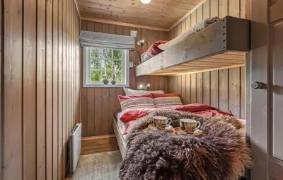 a bedroom with a bed in a wooden room at 2 Bedroom Gorgeous Home In Svingvoll in Svingvoll