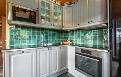 a kitchen with white cabinets and green tile on the wall at 2 Bedroom Gorgeous Home In Svingvoll in Svingvoll