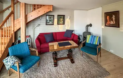 a living room with a red couch and two chairs at 2 Bedroom Awesome Home In Vanvikan in Vannvikan