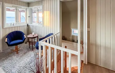 a living room with a blue chair and a table at 2 Bedroom Awesome Home In Vanvikan in Vannvikan
