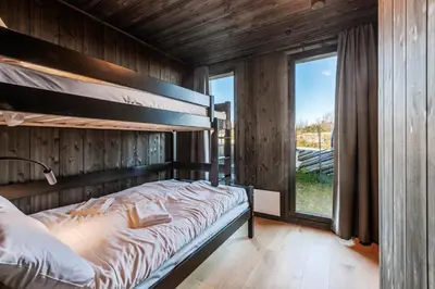 a bedroom with a bunk bed and a window at Kikut Alpin Lodge 2204 in Hol