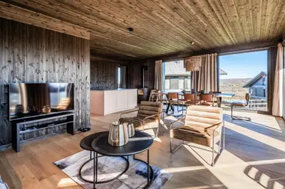 a living room with a television and a table at Kikut Alpin Lodge 2204 in Hol