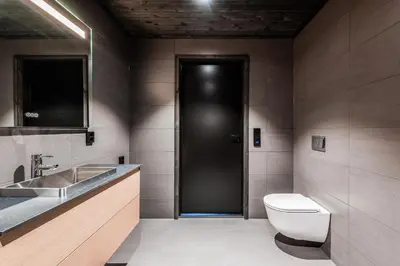 a bathroom with a toilet and a sink and a black door at Kikut Alpin Lodge 2204 in Hol