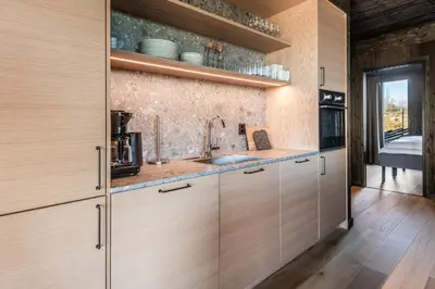 a kitchen with wooden cabinets and a sink at Kikut Alpin Lodge 2204 in Hol
