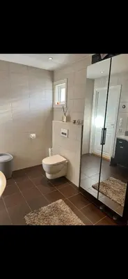 a bathroom with a toilet and a glass shower at Koselig bolig med stor stue, 10 min from Solsiden! in Trondheim