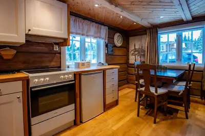 a kitchen with a stove and a dining table at Trysilfjellet Sør 802 Anex in Trysil