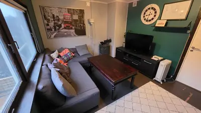 a living room with a couch and a table at Bedroom with private living room in Bergen