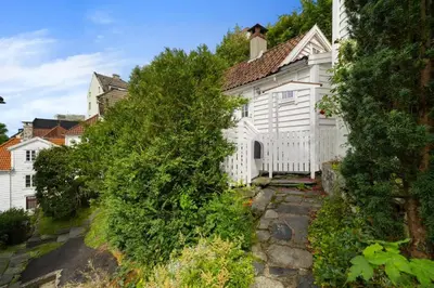 a white house with trees in front of it at Historic Bergen House with Sunny Terrace in Bergen