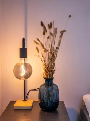 a blue vase with flowers on a table next to a lamp at Historic Bergen House with Sunny Terrace in Bergen