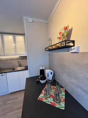 a kitchen with a table with glasses on it at Midt i Raufoss, stor leilighet med hage in Raufoss