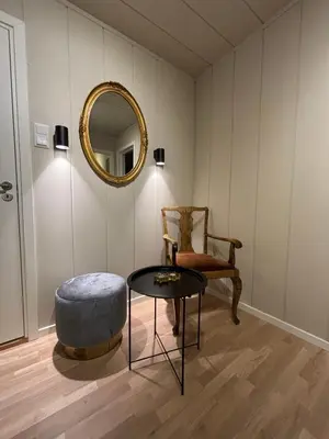 a room with a table and a chair and a mirror at Midt i Raufoss, stor leilighet med hage in Raufoss