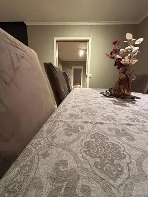 a vase with flowers on a table with chairs at Midt i Raufoss, stor leilighet med hage in Raufoss