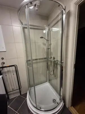 a shower with a glass door in a bathroom at 2 bedroom apartment historical downtown by the sea in Ålesund