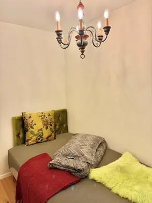 a chandelier hanging over a bed with a pillow at 2 bedroom apartment historical downtown by the sea in Ålesund