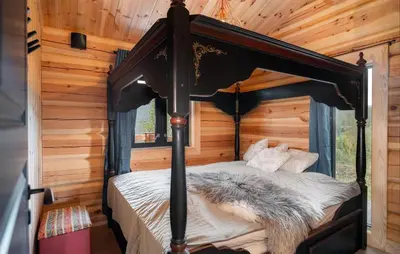 a bedroom with a canopy bed in a log cabin at 5 Bedroom Beautiful Home In Tuddal in Tuddal