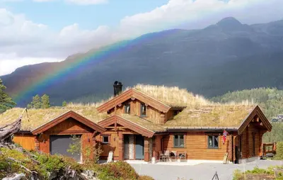 a wooden house with a rainbow in the background at 5 Bedroom Beautiful Home In Tuddal in Tuddal