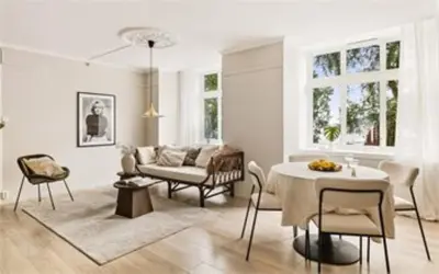 a living room with a table and a couch at Moderne leilighet med sjøgløtt og balkong in Bergen
