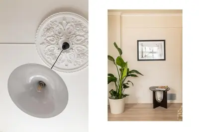 a white plate hanging on a wall next to a plant at Moderne leilighet med sjøgløtt og balkong in Bergen