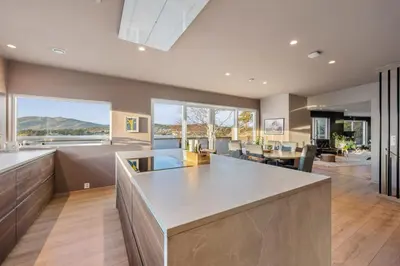 a kitchen with a large island and a large living room at Luxury Seafront Villa with Panoramic Views in Veland